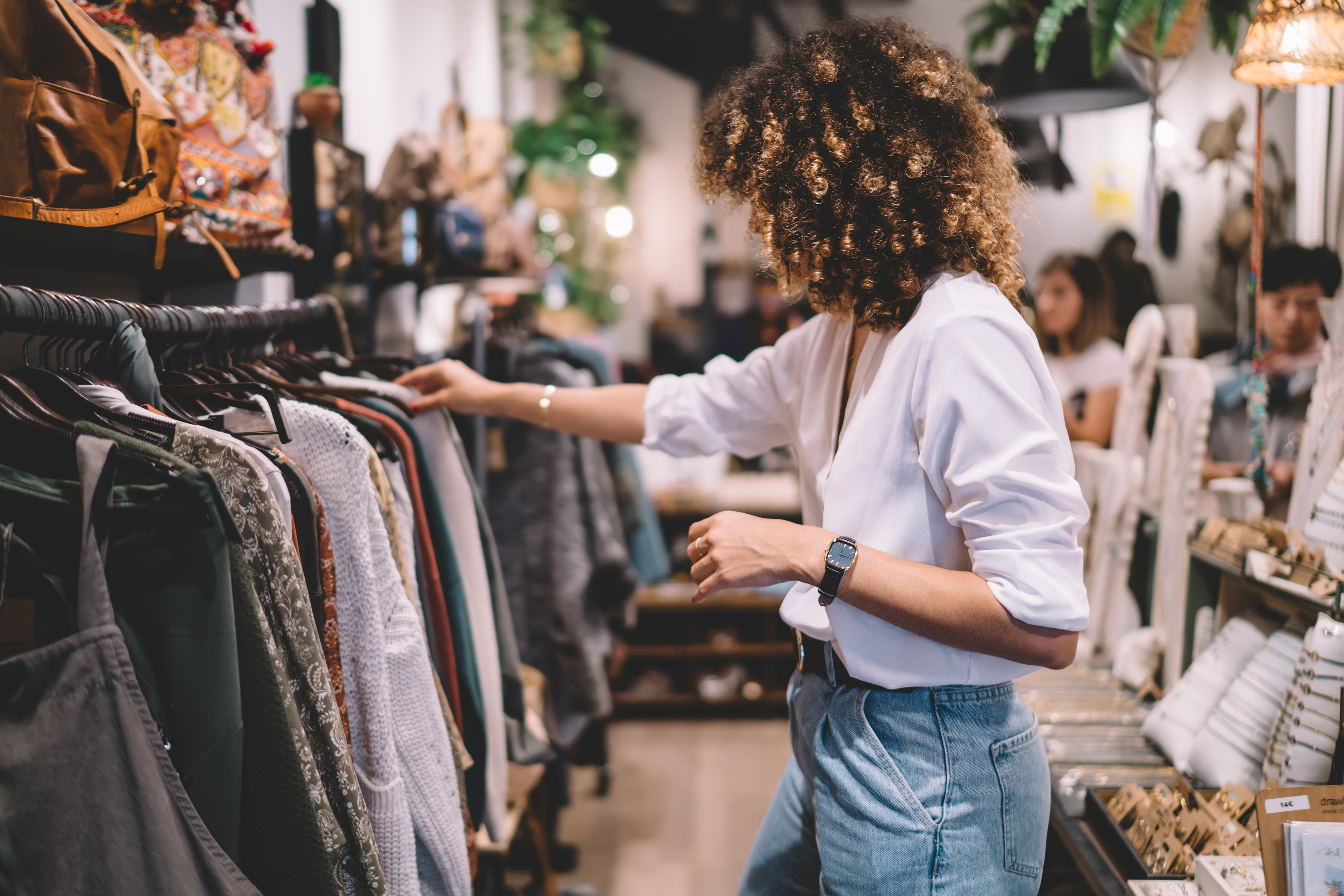Young black woman looking through a clothing rack
